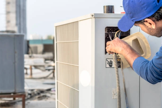 Technician servicing outdoor HVAC unit, inspecting and repairing electrical components. -heating repair service
