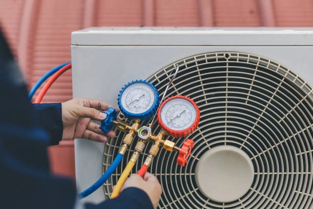 Technician checking air conditioning unit pressure with manifold gauge set. -heating installation