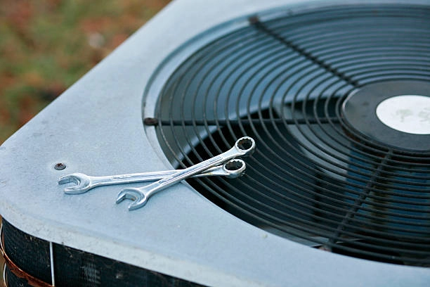 Wrenches placed on top of an outdoor air conditioning unit. -ac repair company