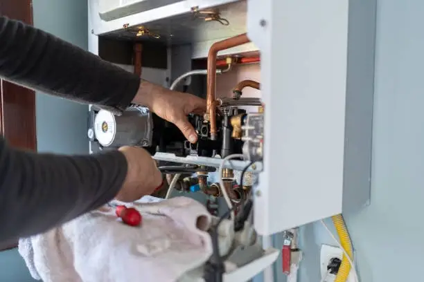 Expert repairs boiler unit during routine heating system maintenance inspection service.
